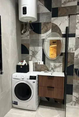 a bathroom with a washing machine and a sink at Studio in Oldtown in Vilnius