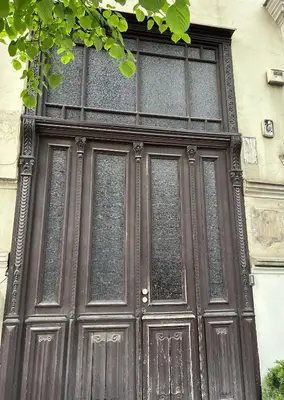 a large wooden door with windows on a building at Studio in Oldtown in Vilnius