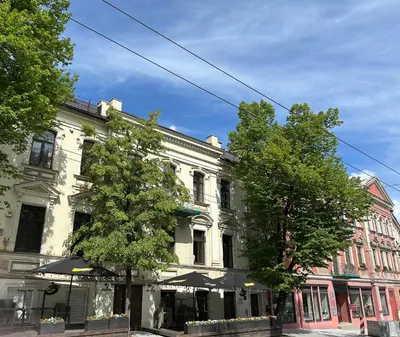 a building on a street with trees in front of it at Studio in Oldtown in Vilnius