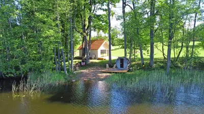 a cabin in the woods next to a body of water at Kiauklių oazė in Kiaukliai