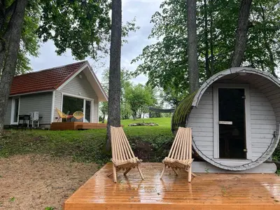a couple of chairs sitting in front of a house at Kiauklių oazė in Kiaukliai