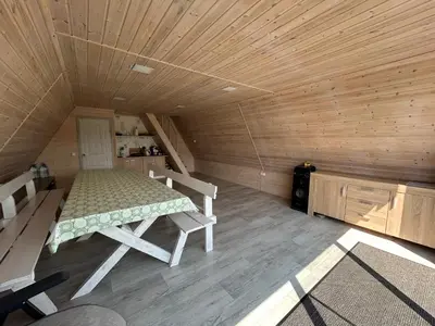 a room with a bed and two chairs in a cabin at A-Spot - A-formos nameliai ir poilsio sodyba in Roglaičiai I