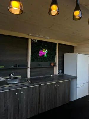 a kitchen with a sink and a refrigerator at A-Spot - A-formos nameliai ir poilsio sodyba in Roglaičiai I