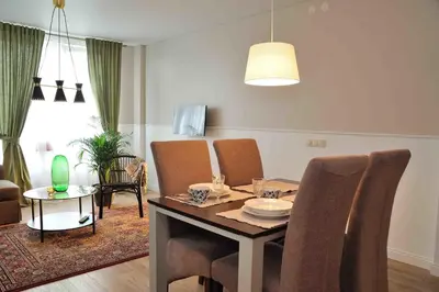 a living room with a dining table and chairs at Dzuku apartment 11 in Vilnius
