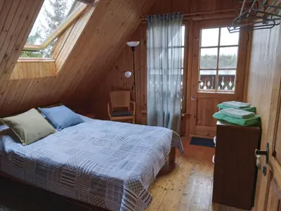 a bedroom with a bed in a wooden house at Lake 4U in Užuguostis