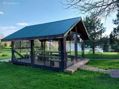 a gazebo with picnic tables in a field at Lake 4U in Užuguostis