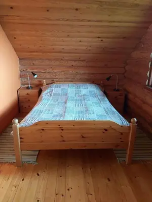 a bed in a wooden room in a cabin at Lake 4U in Užuguostis