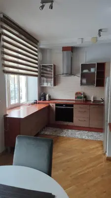 a kitchen with brown cabinets and a counter top at Boulevard house in Šiauliai