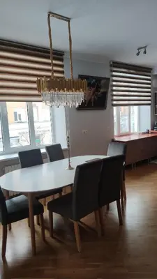 a dining room table with chairs and a chandelier at Boulevard house in Šiauliai
