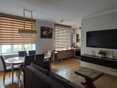 a living room with a couch and a dining room at Boulevard house in Šiauliai