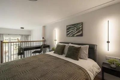 a bedroom with a large bed and a balcony at Loft 62 in Vilnius