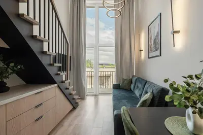 a living room with a blue couch and a staircase at Loft 62 in Vilnius