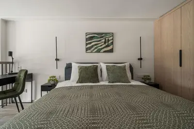a bedroom with a large bed and a desk at Loft 62 in Vilnius