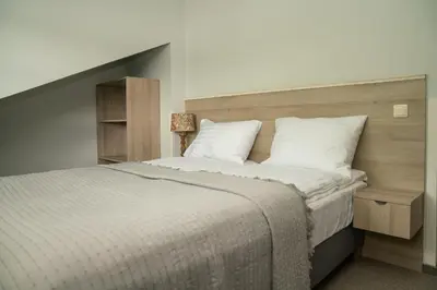 a bedroom with a large bed with a wooden headboard at Birštono Banginukas poilsio namai in Birštonas