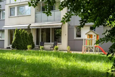 a house with a yard with a playground at Apartment with big terrace in Vilnius
