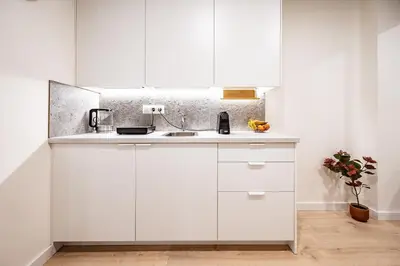 a kitchen with white cabinets and a sink at Cozy 1BR in Old Town with FREE Parking in Vilnius