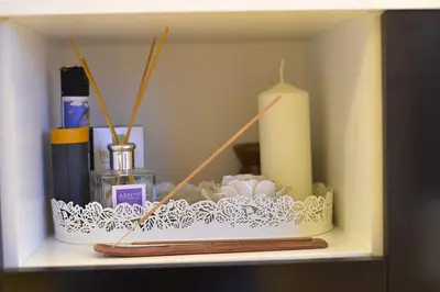 a shelf with a candle and other items on it at Central Apartment with Fireplace & Cathedral View in Šiauliai