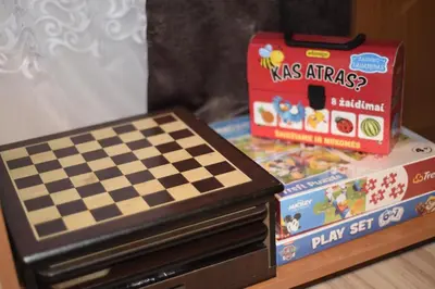 a chessboard and other toys are sitting on a table at Central Apartment with Fireplace & Cathedral View in Šiauliai