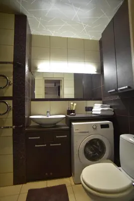 a bathroom with a sink and a washing machine at Central Apartment with Fireplace & Cathedral View in Šiauliai