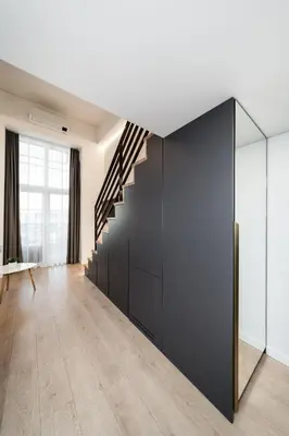 a living room with a black wall and a staircase at Radio Apartment in Kaunas