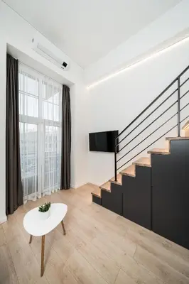 a living room with stairs and a table at Radio Apartment in Kaunas