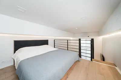 a bedroom with a white bed and a window at Radio Apartment in Kaunas