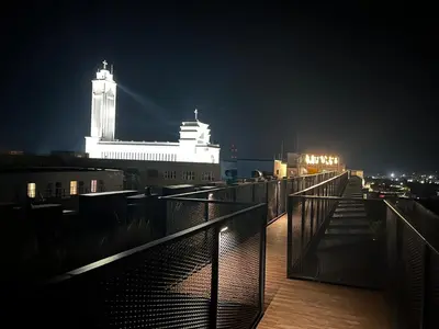 a night view of a building with a clock tower on top at Radio Apartment in Kaunas