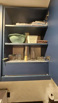 a kitchen shelf with bowls and other items on it at CITY STAY 2-bedroom apartment in Šiauliai