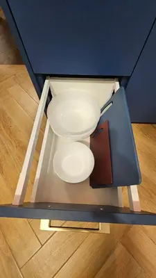 two white plates sitting in a blue cabinet at CITY STAY 2-bedroom apartment in Šiauliai