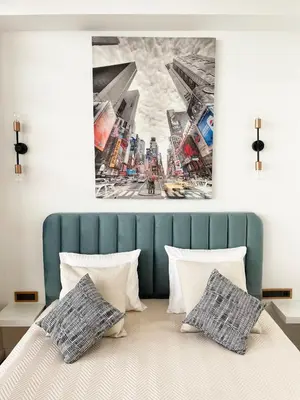 a bedroom with a bed with a painting on the wall at Cozy Vilnius Stay in Vilnius