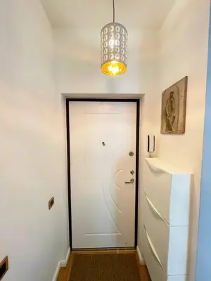 a hallway with a white door and a chandelier at Cozy Vilnius Stay in Vilnius
