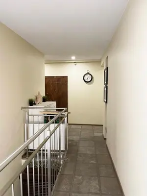 a hallway with a staircase and a clock on the wall at Cozy Vilnius Stay in Vilnius