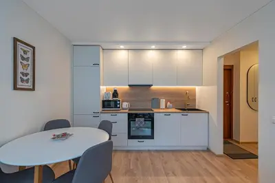 a kitchen and dining room with a table and chairs at Luminious apartment with balcony by Polo Apartments in Kaunas