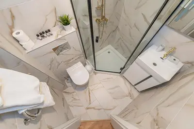 a bathroom with a shower and a toilet and a sink at Luminious apartment with balcony by Polo Apartments in Kaunas