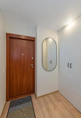 a hallway with a wooden door and a mirror at Luminious apartment with balcony by Polo Apartments in Kaunas