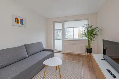 a living room with a couch and a tv at Luminious apartment with balcony by Polo Apartments in Kaunas