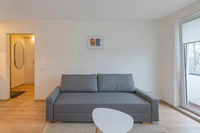 a living room with a couch and a table at Luminious apartment with balcony by Polo Apartments in Kaunas