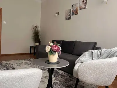 a living room with a couch and a table with a vase of flowers at Vytauto apartamentai centre in Kaunas