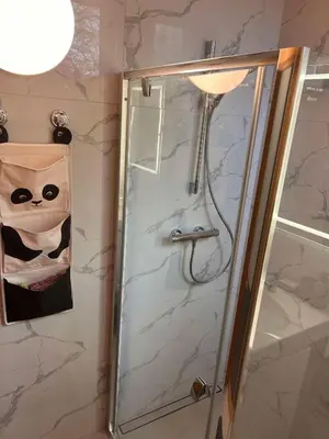 a shower with a glass door in a bathroom at Vytauto apartamentai centre in Kaunas