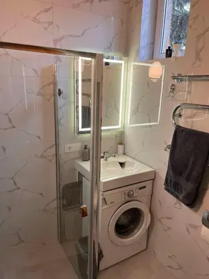 a bathroom with a sink and a washing machine at Vytauto apartamentai centre in Kaunas