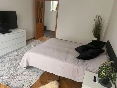 a bedroom with a bed with pillows and a tv at Vytauto apartamentai centre in Kaunas