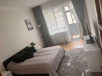a bedroom with a bed and a large window at Vytauto apartamentai centre in Kaunas