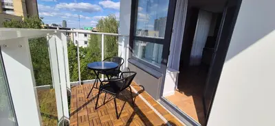 a balcony with two chairs and a table on it at NEW Bright & Stylish 2BR apt in Vilnius