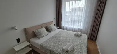 a bedroom with a bed with two pillows and a window at NEW Bright & Stylish 2BR apt in Vilnius