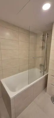 a bathroom with a tub and a glass shower at NEW Bright & Stylish 2BR apt in Vilnius
