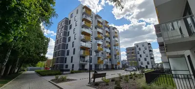 a person sitting on a bench in front of a building at NEW Bright & Stylish 2BR apt in Vilnius