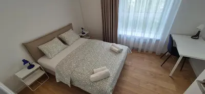 a small bedroom with a bed with a desk and a window at NEW Bright & Stylish 2BR apt in Vilnius