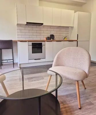a kitchen with a chair and a glass table at Sv2 Marie Oldtown SELF CHECK-IN by QuarterStays in Vilnius