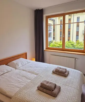 a bedroom with a bed with two towels on it at Sv2 Marie Oldtown SELF CHECK-IN by QuarterStays in Vilnius