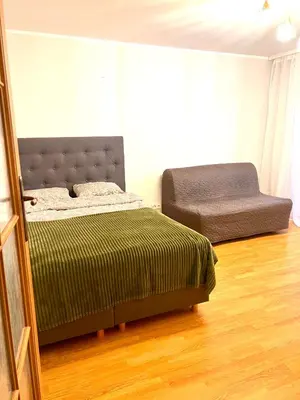 a bedroom with a bed and a chair at Butas Trakuose su vaizdu į ežerus-Lake view apartment in Trakai in Trakai